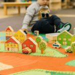 kid playing with small world village set