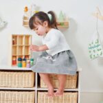 girl playing with wooden family